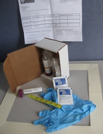 Image of a Maine CDC home lead dust test. Dust wipes, gloves, measuring tape, and test tubes pictured.